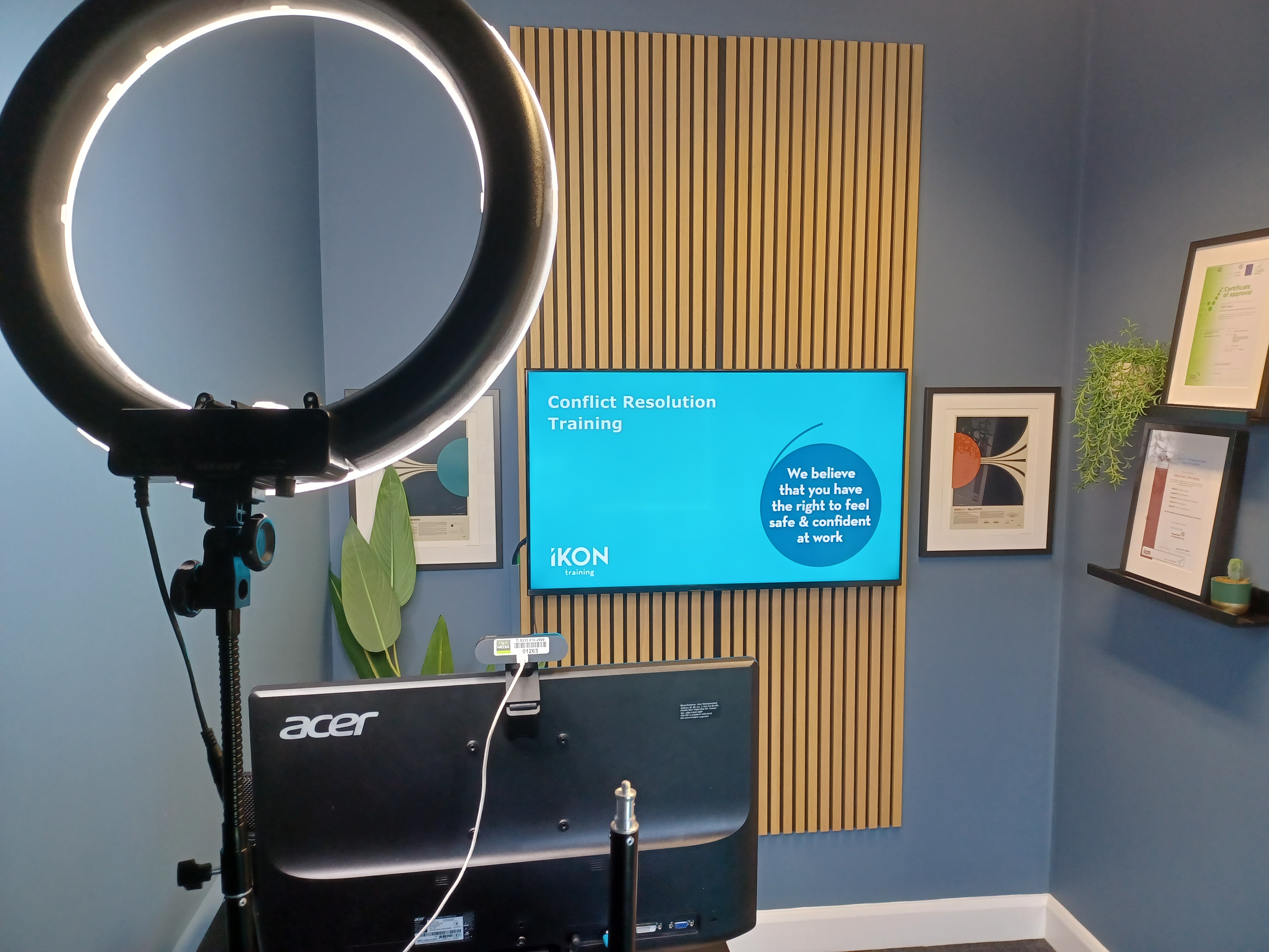 IKON Training online delivery studio - ring light, presentation screen showing Conflict Resolution Training with iKON branding, professional recording setup